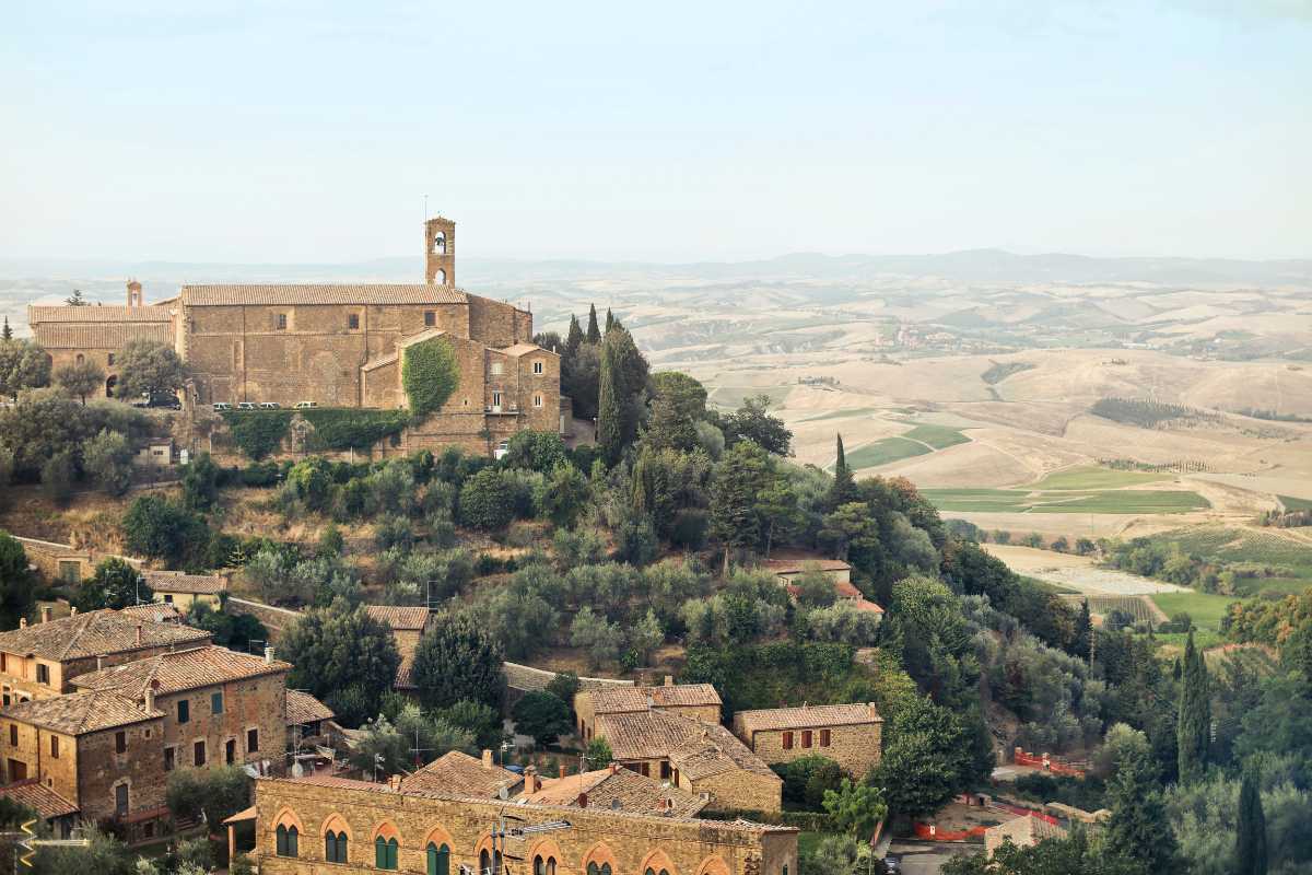 Panorama aereo su Montalcino al tramonto, con vigneti e il borgo storico in evidenza