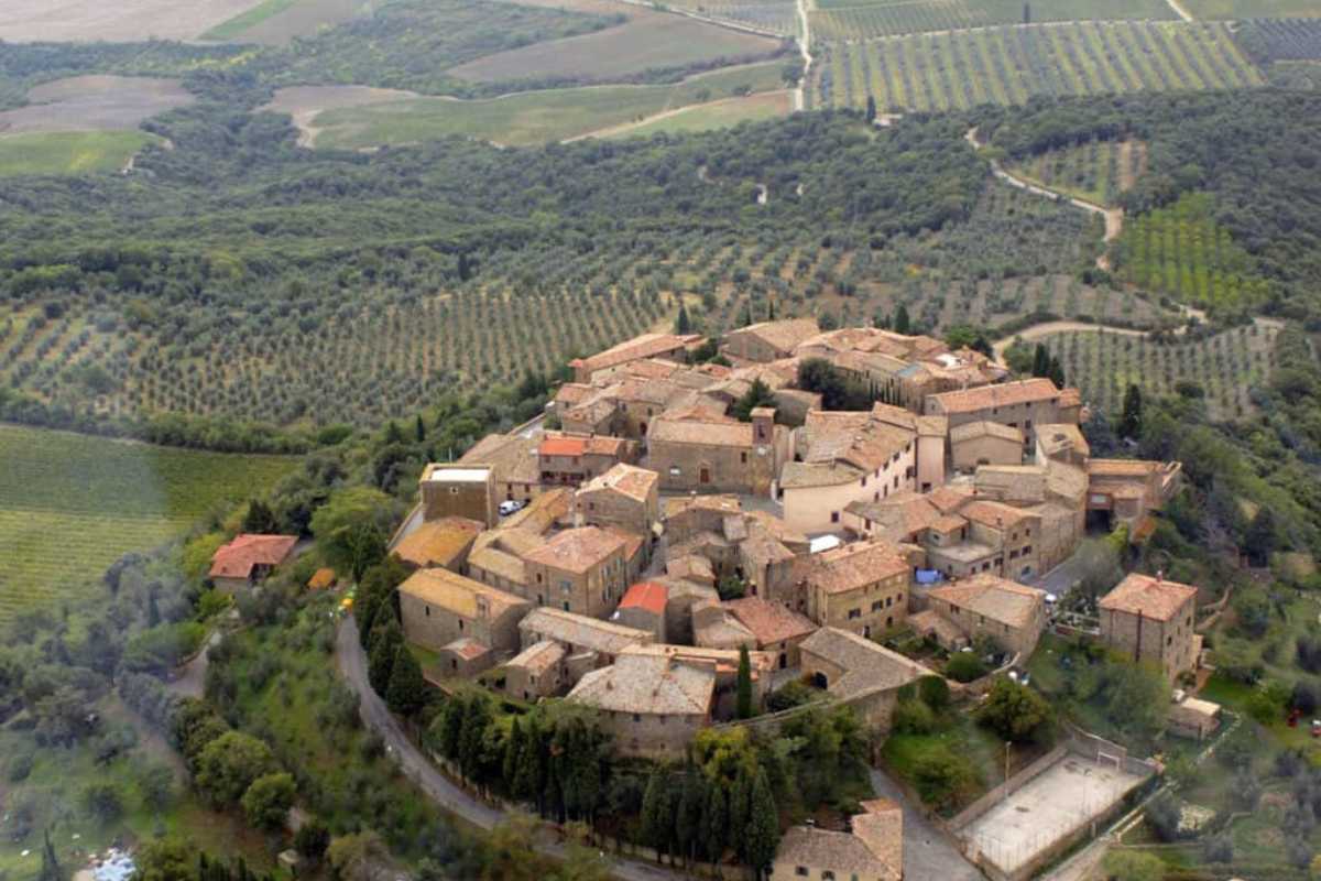 Vista panoramica di Montalcino al tramonto, vigneti sullo sfondo, atmosfera rilassata